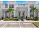 Stunning townhome featuring modern stone accents, white facade, and lovely landscaping at 17230 Blessing Dr, Clermont, FL 34714