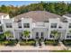 Beautiful townhome exterior with manicured landscaping, stone accents, and palm trees at 17230 Blessing Dr, Clermont, FL 34714