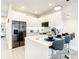 Modern kitchen with white cabinetry, stainless steel appliances, and island seating at 17230 Blessing Dr, Clermont, FL 34714