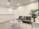 Living area showing a gray sofa with blue pillows, glass coffee table, and neutral carpet at 17230 Blessing Dr, Clermont, FL 34714