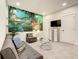 Comfortable living room with a decorative mural, sofa, and entertainment center at 17230 Blessing Dr, Clermont, FL 34714