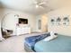 Stylish main bedroom with a ceiling fan, a dresser with TV, and tropical themed wall art above the bed at 17230 Blessing Dr, Clermont, FL 34714