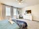 Bright bedroom with a ceiling fan, a dresser with TV, modern decor, and two windows with white blinds at 17230 Blessing Dr, Clermont, FL 34714