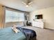 Bright bedroom with a ceiling fan, a dresser with TV, modern decor, and a window with white blinds at 17230 Blessing Dr, Clermont, FL 34714