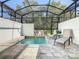 Private screened-in outdoor pool with patio chairs and views of the green trees at 17230 Blessing Dr, Clermont, FL 34714