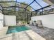Private screened-in outdoor pool with patio chairs and views of the green backyard at 17230 Blessing Dr, Clermont, FL 34714