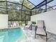 Private screened-in outdoor pool with patio chairs and lush green backyard views at 17230 Blessing Dr, Clermont, FL 34714