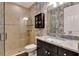 Updated bathroom with stylish wallpaper, a marble countertop, and a glass-enclosed shower at 1767 Piedmont Pl, Lake Mary, FL 32746