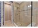 Glass enclosed shower featuring beige tiling and decorative wallpaper located next to an entry doorway at 1767 Piedmont Pl, Lake Mary, FL 32746