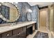 Bathroom featuring a double sink vanity with granite countertop and decorative blue wallpaper at 1767 Piedmont Pl, Lake Mary, FL 32746