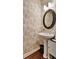 Chic powder room with decorative wallpaper, a pedestal sink, and a modern mirror at 1767 Piedmont Pl, Lake Mary, FL 32746