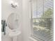 Bathroom with pedestal sink, modern faucet and window providing natural light at 17985 Adrift Rd, Winter Garden, FL 34787