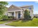 Charming home featuring manicured lawn, lush landscaping, inviting front porch and classic architectural details at 17985 Adrift Rd, Winter Garden, FL 34787