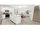 Open concept kitchen with white cabinetry, an island, and access to the living and dining areas at 17985 Adrift Rd, Winter Garden, FL 34787