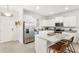 Open concept kitchen with island seating, white cabinetry, and stainless steel appliances at 17985 Adrift Rd, Winter Garden, FL 34787