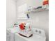 Bright laundry room with modern appliances, convenient shelving, and natural light from the window at 17985 Adrift Rd, Winter Garden, FL 34787