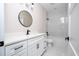 Bathroom featuring a white vanity with black fixtures, round mirrors and tub at 2041 Warrens Ave, Maitland, FL 32751