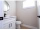 Modern half bathroom features a round mirror, white vanity and contemporary black fixtures at 2041 Warrens Ave, Maitland, FL 32751