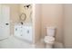 Bathroom with dual sinks, white vanity and cabinetry, with tiled flooring and modern fixtures at 2041 Warrens Ave, Maitland, FL 32751