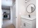 Modern bathroom featuring white vanity with black hardware and faucet and a round mirror at 2041 Warrens Ave, Maitland, FL 32751
