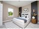 Stylishly decorated bedroom featuring a large window, a queen bed, and a striped rug at 2041 Warrens Ave, Maitland, FL 32751