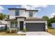 Beautiful two-story home with a dark gray garage door and a well-manicured lawn with blue sky in the background at 2041 Warrens Ave, Maitland, FL 32751