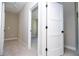 Hallway with neutral carpet leading to an open doorway and a closed white door at 2041 Warrens Ave, Maitland, FL 32751