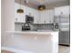 Modern kitchen features white cabinets, a stainless steel refrigerator, microwave, and unique backsplash at 2041 Warrens Ave, Maitland, FL 32751