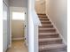 Carpeted staircase leading upstairs, adjacent to a door leading to a room with wood-look flooring at 2041 Warrens Ave, Maitland, FL 32751