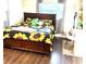 Bright bedroom featuring a sunflower themed bedspread, natural light, and a dedicated workspace at 213 S Lake Pleasant Rd, Apopka, FL 32703