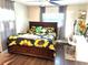 Cozy bedroom featuring a sunflower-themed bedspread, wood floors, and a bright desk area at 213 S Lake Pleasant Rd, Apopka, FL 32703