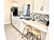 Charming kitchen with white cabinets, tiled backsplash, stainless steel appliances, and breakfast bar seating at 213 S Lake Pleasant Rd, Apopka, FL 32703