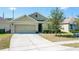 View of single story home with neutral exterior, trimmed shrubs, two-car garage and concrete driveway at 2312 Rose Blvd, Winter Haven, FL 33881