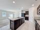 Modern kitchen with center island, dark wood cabinets, black appliances, and neutral tile flooring at 2312 Rose Blvd, Winter Haven, FL 33881