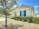 A side view of a single-story home with trimmed shrubbery, light-colored siding, and dark shutters at 2312 Rose Blvd, Winter Haven, FL 33881