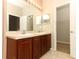 Bathroom featuring double sinks, dark wood cabinets, tile floors, and a doorway to a walk-in closet at 2530 San Jacinto Cir # 2530, Sanford, FL 32771