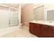Bathroom showcasing tile floors, a dual-sink vanity with dark wood cabinets, and a glass-enclosed shower at 2530 San Jacinto Cir # 2530, Sanford, FL 32771