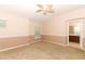 Spacious bedroom with a ceiling fan, two windows, carpeted floor, and a doorway leading to an attached bathroom at 2530 San Jacinto Cir # 2530, Sanford, FL 32771