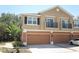 Townhouse with brown garage doors, beige siding, and small balconies at 2530 San Jacinto Cir # 2530, Sanford, FL 32771