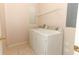 Bright laundry room featuring a white washer and dryer, tile flooring, and a wire rack above the appliances at 2530 San Jacinto Cir # 2530, Sanford, FL 32771