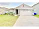 Charming single-Gathering home features a well-manicured lawn, two-car garage, and neatly planted shrubs at 2637 Rowan St, Tavares, FL 32778