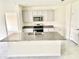 Modern kitchen with granite countertops, stainless steel appliances, and central island with sink at 2637 Rowan St, Tavares, FL 32778