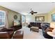 Comfortable living room with a ceiling fan, media center, and comfortable leather seating arrangement at 2704 Gorst Rd, Winter Garden, FL 34787