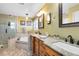 Relaxing bathroom with dual sinks, garden tub, and separate glass-enclosed shower with neutral tile at 2704 Gorst Rd, Winter Garden, FL 34787
