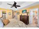 Cozy main bedroom with tray ceiling, ceiling fan, and an ensuite bathroom with a soaking tub at 2704 Gorst Rd, Winter Garden, FL 34787