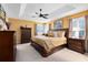 Serene main bedroom features tray ceilings, ceiling fan, and large windows providing natural light at 2704 Gorst Rd, Winter Garden, FL 34787