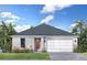 Charming single-story home with a two-car garage and well-maintained lawn surrounded by tropical landscaping at 30330 Emerald Forest Dr, Mount Dora, FL 32757