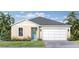 Inviting single-story home with a two-car garage and well-manicured lawn complemented by lush tropical foliage at 30330 Emerald Forest Dr, Mount Dora, FL 32757