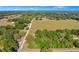 Wide aerial shot showing a field with scattered trees and a long driveway leading to a home at 36208 Micro Racetrack Rd, Fruitland Park, FL 34731