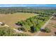 Expansive land offering a lush green space surrounded by mature trees and a winding road at 36208 Micro Racetrack Rd, Fruitland Park, FL 34731